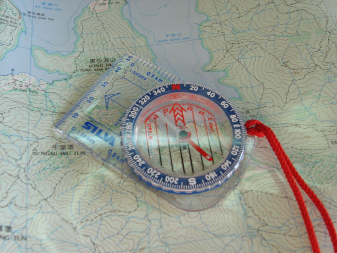 Photograph of a baseplate compass with rotating bezel, magnetic needle, and direction-of-travel arrow